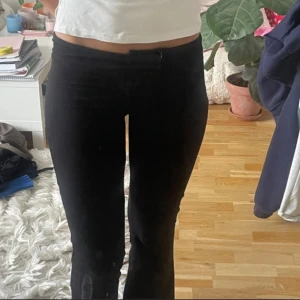 Svarta bootcut byxor med låg midja - Säljer ett par svarta byxor med låg midja och bootcut-ben. De har en tight passform upptill och släpper ut nedtill för en snygg siluett. Perfekta till sneakers eller boots och riktigt sköna att bära hela dagen.