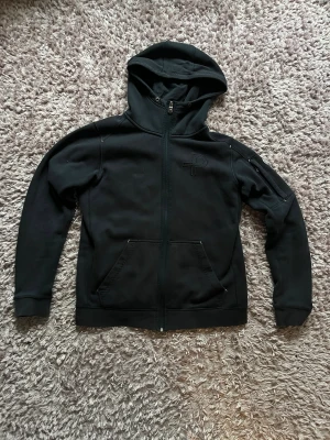 Mörkblå hoodie från Pelle P i storlek L - Mörkblå hoodie från Pelle P med dragkedja hela vägen, broderad logga på bröstet och två stora fickor framtill. Tröjan har huva och är tillverkad i mjuk bomullsblandning med fleecefoder på insidan. Perfekt för kyliga dagar. Storlek L men passar M perfekt. Tveka inte att höra av er vid funderingar eller mer bilder 😁Bvsa 