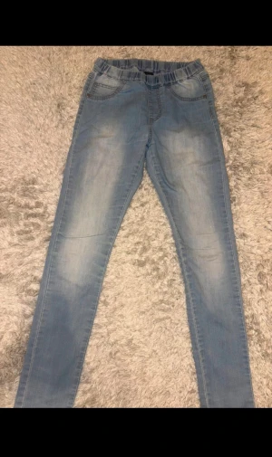 Ljusblå skinny jeans från KappAhl - Ljusblåa jeans till barn i storlek 152, har en liten vit fläck på framsida av låret men inget man lägger märke till (se bild 4)