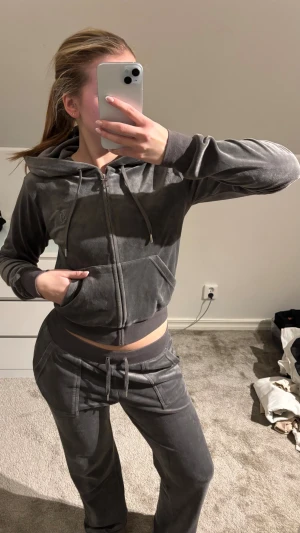 Grått Juicy Couture sett - Mysigt grått mjukissett från Juicy Couture. Byxorna har fickor fram och bak med snygga detaljer. Byxorna är i M tröjan är i stl S. Båda ingår i annonsen