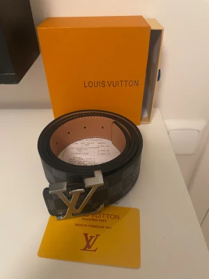 Svart rutigt bälte - Säljer ett svart rutigt bälte med allt som är på bilden låda kvitt och ett certifikat 