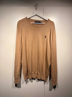 Beige tröja från Polo Ralph Lauren - Säljer en beige långärmad tröja från Polo Ralph Lauren i slim fit. Perfekt för dig som gillar stilrena och klassiska plagg. Inga defekter på tröjan. Priset går att diskutera.
