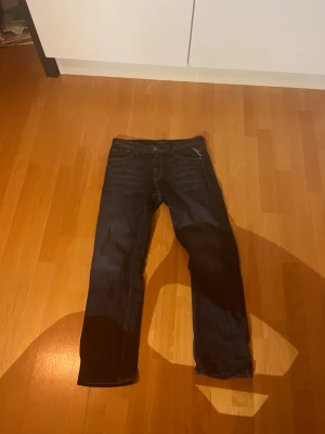 Replay Thad jeans mörkblå, 14A - Snygga mörkblå jeans från Replay, modell Thad, med klassisk femficksdesign och gul kontrastsöm. Byxorna har rak passform och är tillverkade i slitstarkt jeanstyg. Detalj med röd Replay-logga vid bakfickan och läderpatch i midjan.