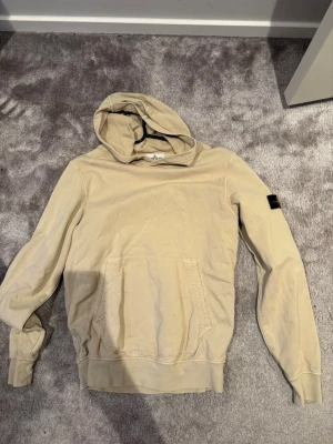  Stone Island hoodie - Säljer en lime grön hoodie från Stone Island Junior med klassisk logotyp-patch på vänster ärm. Tröjan har huva, magficka och ribbade muddar. Perfekt för dig som gillar streetwear och vill ha något stilrent och bekvämt. 170 junior storlek