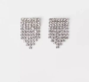 Glittriga silverörhängen med strass - Säljer ett par snygga örhängen i silverfärg med glittrande strassstenar. De har en bred, rektangulär form som smalnar av mot spetsen och ger ett statement-look. Perfekta för dig som vill sticka ut med extra bling och cool stil.