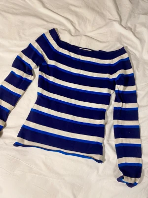 Halvt off-shoulder blå randig långärmad från hm - Superfin, rätt så tight, randig "stickad" trlja från hm. Den är lite nopprig på vissa ställen men jag tycker inte det märks så mycket. Den har syperfint mönster med blåa och vita ränder. 
