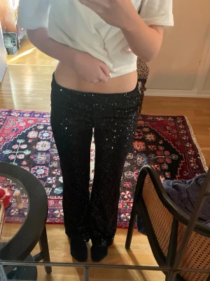 Paljett byxor  - Snygga svarta paljettbyxor som är använda en gång. Går att ha lowwaist och normalt. Lätt att vika in då det finns en tjockt band i midjan. Jag är 165cm. 