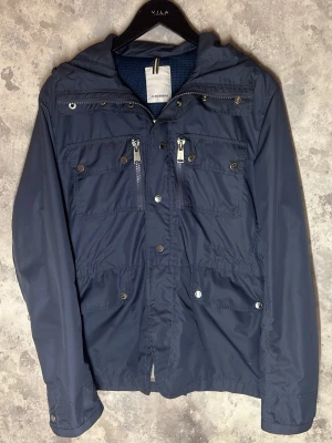 J.Lindeberg Field Jacket - Säljer denna riktigt snygga Field jacket från J.Lindeberg. Jackan är i bra skick utan defekter och är i storlek L. Bara att skriva över frågor och funderingar.