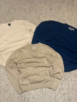 Tre stickade tröjor från H&M, Dobber & Sweater Graphic (Bundle) - Säljer tre stickade tröjor i olika färger och märken. En beige från H&M, en ljusbeige från Dobber och en mörkblå från Sweater Graphic. Storlekarna är S,S,L men alla passar M
