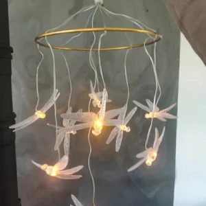 SKINA ljusslinga med trollsländor - Unik ljusslinga från SKINA med transparenta trollsländor som hänger från en rund guldfärgad ring. LED-lampor i sländorna ger ett mysigt sken. Perfekt som dekoration i sovrum eller vardagsrum. Säljes i originalförpackning.