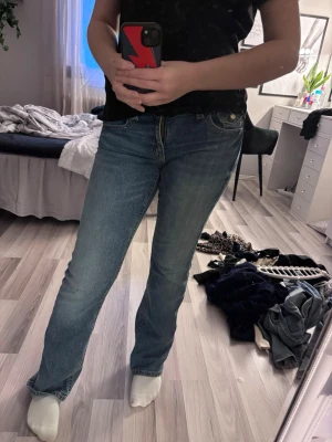 Blå bootcut jeans med fickdetaljer - Säljer ett par blå jeans med bootcut-snitt och snygga fickdetaljer bak. Jeansen har klassisk femficksdesign, normal passform och är tillverkade i jeansmaterial. Perfekta för dig som gillar en tidlös look med lite extra edge. Använda runt 5 gånger och har inga defekter. Sitter superbra och är sköna att ha på sig. Är från Gina tricot i stl 170, men sitter som en S. Bara att höra av dig vid frågor eller fler bilder💕