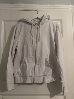 Sip hoodie från H&M - Säljer en vit sip hoodie från H&M i storlek M. Den har luva och snören. Den var tecken på användning då den är lite nopprig. 🩷