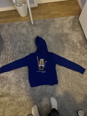 Polo Ralph Lauren Hoodie - Säljer en skön Ralph Lauren hoodie i färgen blå. Den är för folk som vill känna sig lyxig lite extra. Storlek 14-16 år. Nypris är runt 2000 om inte mer. Folk kallar denna ”Grish”