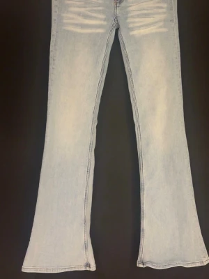 Bootcut ljusa jeans med slitningar - Snygga ljusblå jeans med bootcut-snitt och coola slitningar framtill. Jeansen har klassisk femficksdesign och är tillverkade i mjukt denim-material. Perfekta för dig som gillar retrovibbar och vill sticka ut med en avslappnad stil. Cheap Monday jeans!! Använda 1 gång så i ny skick, storlek 29/34