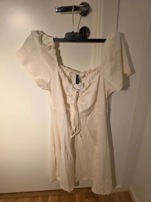 Miniklänning med spetskant och dragsko - Klänning i ribbad trikå köpt från H&M. Prislappen är kvar, dock har den legat oanvänd i min garderob i några månader. 