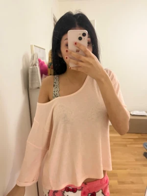 Ljusrosa topp med spetsdetalj i ryggen - Superfin ljusrosa topp med lös passform och trekvartsärm. ryggen har snygga spetsdetaljer 