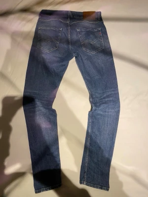 Replay MICKYM jeans slim tapered blå - Snygga blå jeans från Replay, modell MICKYM med slim tapered fit. Klassisk femficksdesign, ljusbrun läderpatch bak och Replay-logga på fickan. Jeansen är gjorda i jeansmaterial och har raka ben med smalare passform upptill.