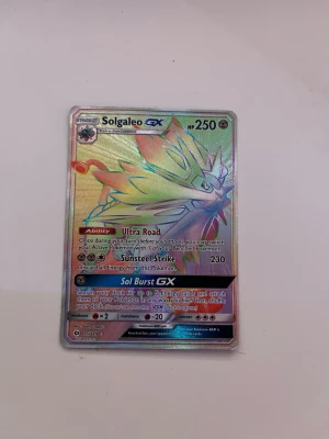 Pokémon kort solgaleo - Solgaleo rainbow gx. Bilderna visar ett Pokémonkort, inte en väst. Ingen information om väst, färg, form, märke eller material kan utläsas.