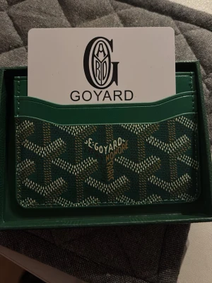 Goyard plånbok - Säljer en grön plånbok från Goyard Plånboken är tillverkad i skinn och har flera fack för kort. Fantastisk kvalité och är perfekt för den som eftersträvar en sådana plånbok. Hör av er vid minsta intresse🏌️💸