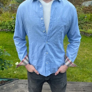 Blå Burberry skjorta ljusblå M - Säljer en äkta burberry skjorta i storlek M. Den är väldigt fin och kostar ca 4000 kr ny, mitt pris är endast 749! Hör av dig vid frågor😁