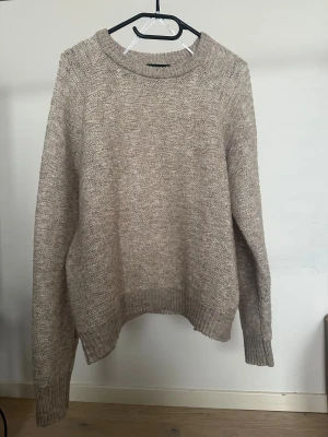 Beige stickad tröja från Pieces - Säljer en beige stickad tröja från Pieces i storlek L. Tröjan har ett strukturerat mönster, rund hals och ribbade muddar vid ärmslut och nederkant.   Obs: Alla plagg säljs endast fram till 28/12 