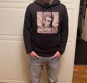 Limitato hoodie  - Svart hoodie med snyggt tryck , samt en stor ficka fram till Hoodien har lång ärm och en relaxed passform, perfekt för chill dagar .ja på bilden är 165 