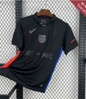 Svart FC Barcelona Travis scott fotbollströja Nike - Snygg svart FC Barcelona fotbollströja från Nike med klubbmärke på bröstet och färgdetaljer i rött och blått längs sidorna. Kortärmad modell med tryck på ärmarna och UNHCR-logga på ryggen. Tillverkad i lätt och ventilerande polyester.
