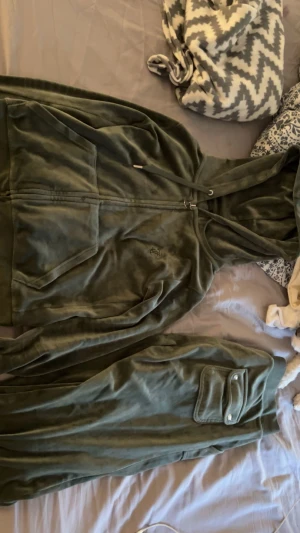 Olivgrönt Juicyset i sammet - Säljer ett olivgrönt Juicyset sammet. Byxorna har fickor där bak med knappar på. Väldigt fint, nyskick skulle jag säga. Har inte kommit till användning bara o passar nu inte längre.🙂‍↔️Hela setet säljs för 1250. Vill du köpa separat diskuteras pris privat. Har du frågat så är de bara att skriva☺️