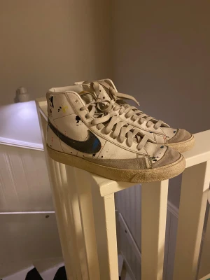 Nike Blazer Mid med färgstänk - Säljer ett par riks-schyssta  pjucks från Nike i modellen Blazer, de är mid skor samt har lite färgstänk men tecken på användning. Skicket är 8/10 samt pris kan diskuteras, hojta till vid övriga funderingar 👍