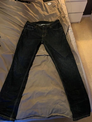 Mörkblå slim jeans från Vailent W32 L30 - Snygga mörkblå jeans från Vailent i slim fit-modell strl . Klassisk femficksdesign med kontrastsömmar och läderpatch bak i midjan. Jeansen har normal passform och är tillverkade i slitstarkt denimtyg. Perfekt för dig som gillar stilrena och tidlösa jeans.
