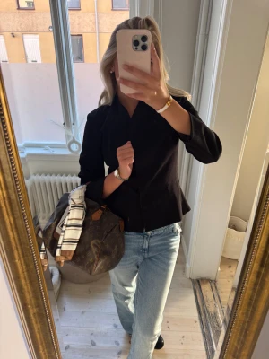 Svart kavaj med minimalistisk look - Snygg svart kavaj med stilren och minimalistisk design. Modellen har lång ärm, smal krage och rak passform som ger en clean siluett. Perfekt att styla med jeans eller dressade byxor för en cool vibe.