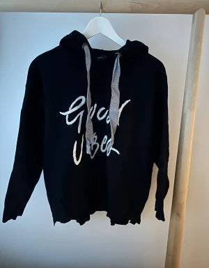 Svart hoodie med Good Vibes-tryck - Svart hoodie från Zara med stort vitt 'Good Vibes'-tryck på framsidan. Tröjan har huva med breda grå snören och lång ärm. Mjuk och skön bomullskänsla.