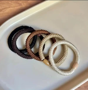  hårband  - Säljer ett set med snygga flätade hårband. De  har en rund form och är tillverkade av syntetmaterial med en enkel pärldetalj. Perfekt för dig som gillar stilrena accessoarer i jordnära färger.
