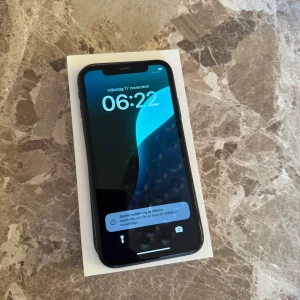 Apple iPhone 11  - Säljer min iPhone 11, 64GB i svart. Telefonen är väl omhändertagen och i bra skick. Batterihälsan ligger på 76%. Den har alltid använts med skärmskydd och skal, så skärmen är i princip repfri. Det finns några mindre tecken på användning runt kanterna, men inget som påverkar funktionen.Den klarar alla vanliga appar och funktioner utan problem. Ljudet är lite sisådär men funkar!  -   64GB lagring -   Batterihälsa 76%