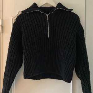 Svart stickad tröja med half zip - Säljer en svart, grovstickad tröja med krage och half zip-dragkedja framtill. Tröjan har långärmade, ribbade muddar och en loose passform som ger en chill vibe. Perfekt för kalla dagar när du vill vara både bekväm och snygg. Storlek XS men passar även S💕