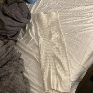Vit ribbad långkjol från Zara - Säljer en snygg vit långkjol från Zara i storlek M. Kjolen är ribbad med en elastisk midja och har en rak, slim passform som ger en clean och modern look. Perfekt att styla med crop tops eller hoodies för en chill vibe.