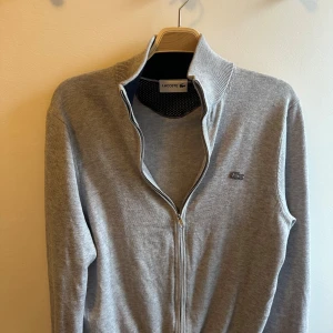 Lacoste zip - Säljer nu denna riktigt feta Lacoste zipen som är i färgen ljusgrå. Den är i väldigt bra skick. Tveka inte på att höra av dig om du undrar över något🤩