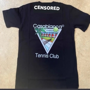 Svart Casablanca Tennis Club t-shirt - Svart t-shirt från Casablanca med färgglatt tryck på ryggen som visar en tennisbana, palmer och texten 'Tennis Club'. : SAMMA DAG DU KÖPER SAMMA DAG JAG FRAKTAR .