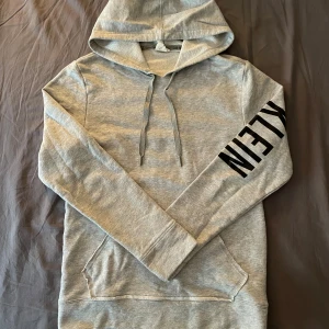 Calvin Klein hoodie - Snygg grå calvin clein hoodie i jättebraskick. Inga deffekter, storlek S. logga på fram o baksidan av armen se bilder. Priset kan diskuteras.