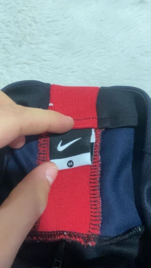 PSG långärmad träningströja Nike står M men passar S  - Snygg långärmad PSG träningströja från Nike i mörkblått med röd Nike-logga och PSG-emblem på bröstet. Tröjan har halv dragkedja och är tillverkad i ett lätt, tekniskt material som andas. Perfekt för fotbollsträning eller att representera ditt lag.