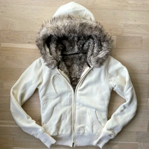 Vintage zipup hoodie med päls - Fraktar elr möts upp! Har inget märke, skulle säga är en storlek s-m, och har även en avtagbar päls på luvan, se bilder. Den är en krämaktig färg, inte helt vit😍