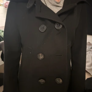 Skepparkappa - Svart Skepparkappa skit snygg saknar dock knappen i mitten men lätt att sy fast en ny plus så ser man det knappt när man stänger den