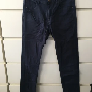 Mörkblå byxor från Kids by Lindex - Säljer ett par mörkblå byxor från märket Kids Lindex. Storlek: Eur 170, UK 14 Y, CN 170/72A. De har en klassisk design med en rak passform och är i mycket bra skick.