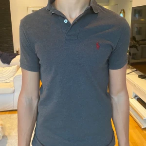 Ralph Lauren piké  - Säljer en skön mörkgrå pikétröja från Ralph Lauren i storlek S men passar även XS. Knappast använd och är i perfekt skick! Skriv gärna vid funderingar!