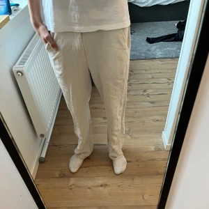 Beige byxor från Grunt - Säljer ett par bekväma beige byxor från Grunt i storlek L/170. De har en loose passform och är perfekta för en avslappnad stil. Byxorna är gjorda i bomull och inne. Perfekt till allt men speciellt på sommaren 