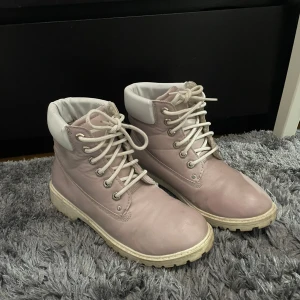 Ljusrosa boots med snörning - Säljer ett par ljusrosa boots från Zgo i syntetmaterial. De har en robust sula och snörning framtill. Perfekta för höst och vinter med sin bekväma passform och stilrena design. Använda men i bra skick!