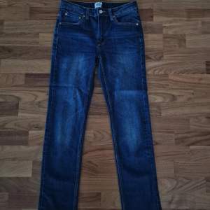 Säljer ett par mörkblå jeans från 157 i storlek 30/32. De har en slim fit och är perfekta för både vardag och fest. Jeansen har klassisk femficksdesign och en knappgylf. Materialet är slitstarkt och bekvämt, vilket gör dem till ett bra val för alla tillfällen.