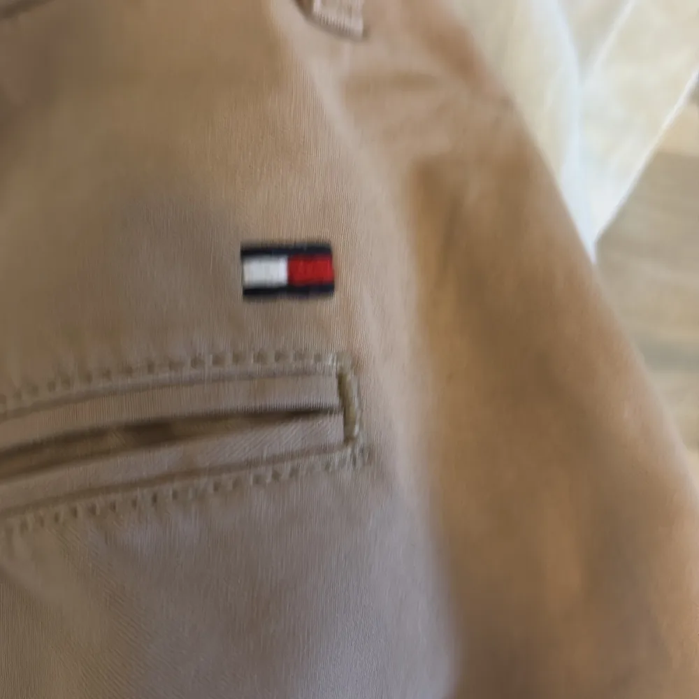 Säljer ett par snygga beige shorts från Tommy Hilfiger i storlek 31. De är i bra skick och perfekta för sommaren. Har inga defekter och passar killar mellan 168-180. Nypris ligger på ungefär 650 som jag köpte de för!. Shorts.