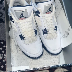 Nike Air Jordans i vitt och blått - Säljer ett par Nike Air Jordans i vitt med blå och grå detaljer. Skorna har en klassisk design med snörning och en bekväm passform. Perfekta för både vardag och sportiga aktiviteter. Sulan har en cool röd detalj under. Ny pris är 5000kr köpta från merchsweden kvitto o allt finns kvar