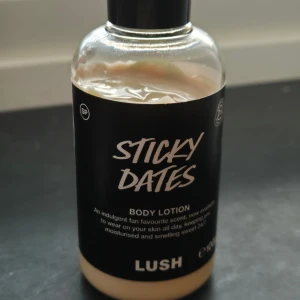 Sticky Dates Body Lotion från Lush - En lyxig body lotion med doft av söta dadlar från Lush. Perfekt för att hålla huden återfuktad och väldoftande hela dagen. Flaskan är stilren med svart etikett och vit text. Ca 80% kvar. Är 100g - alltså den mindre flaskan.